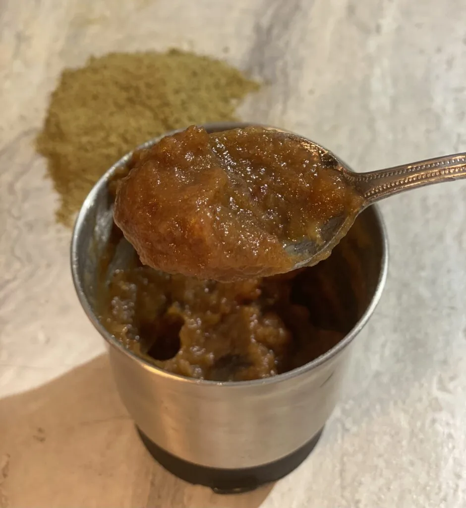 Spoonful of date paste in a small metal container