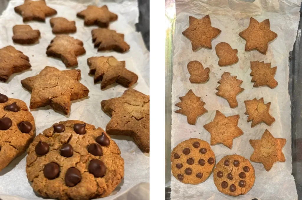 freshly baked cookies. a mix of star, tree, and heart-shaped cookies, and chocolate chip-topped round cookies.