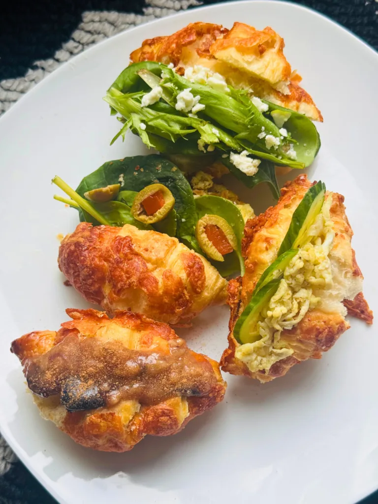 A plate of mini croissant sandwiches with various fillings