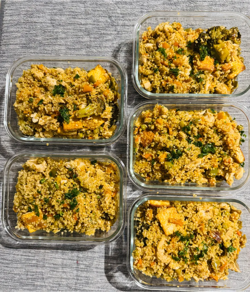 Meal-prepped chicken quinoa pulao stored in glass containers.