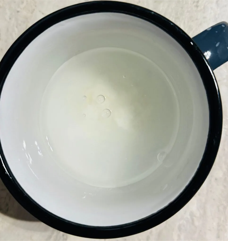 A cup of water mixed with cornstarch, used for thickening the sauce.