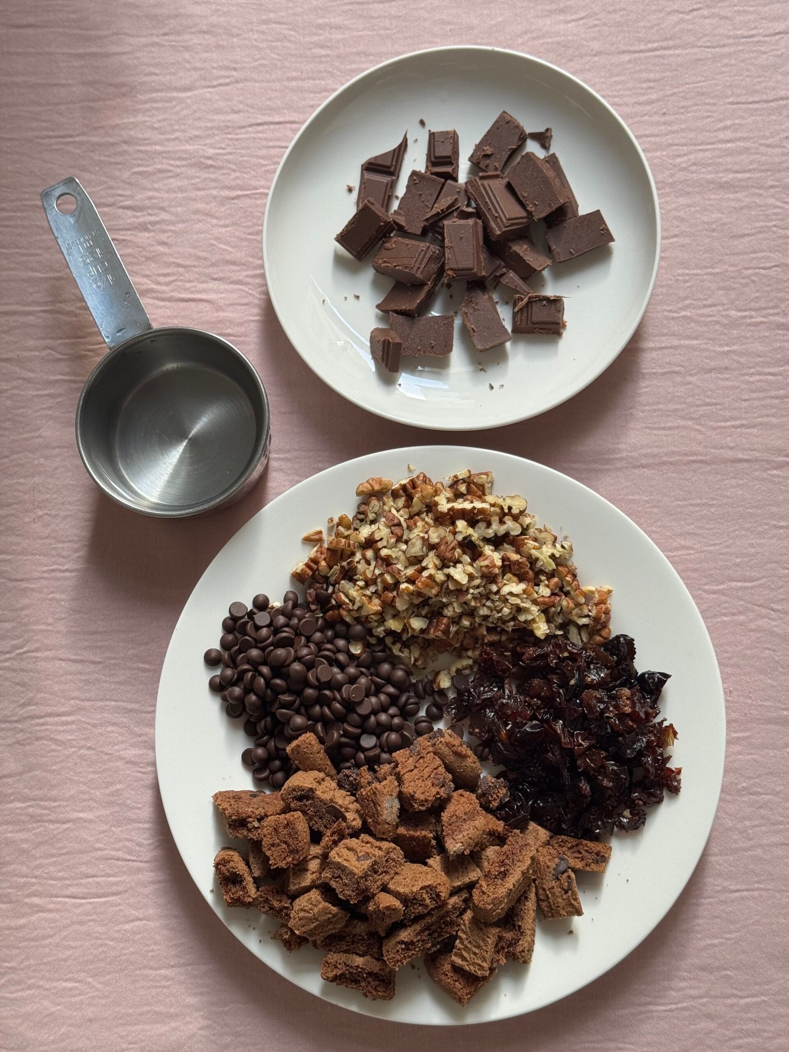 Ingredients for gluten-free monster cookies: chopped dark chocolate, dairy-free chocolate chips, chopped pecans, raisins, and broken gluten-free chocolate chip cookies.