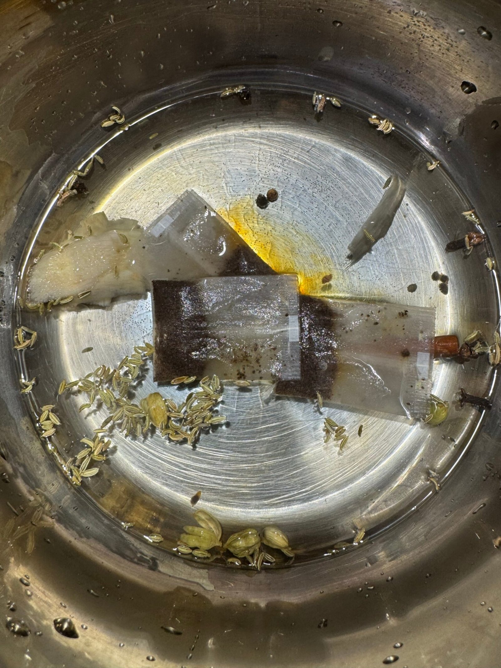 Tea bags, whole spices, ginger, and saffron in a dry saucepan before adding water.