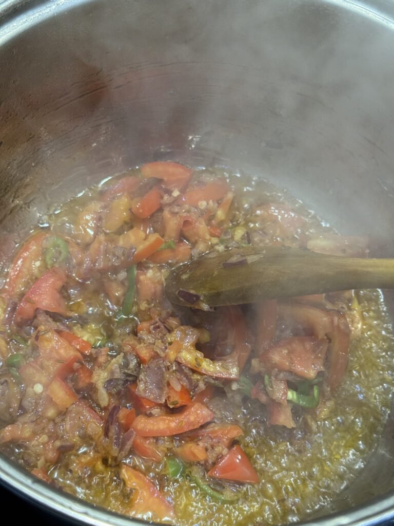 Chopped tomatoes, green chilies, and ginger garlic paste cooking down into a smooth base