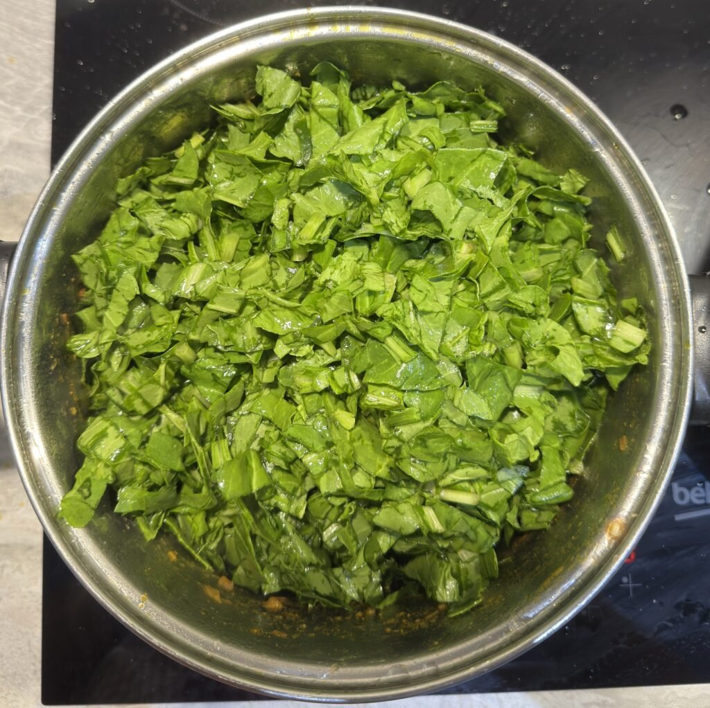 Fresh chopped spinach piled on top of spiced potatoes before steaming