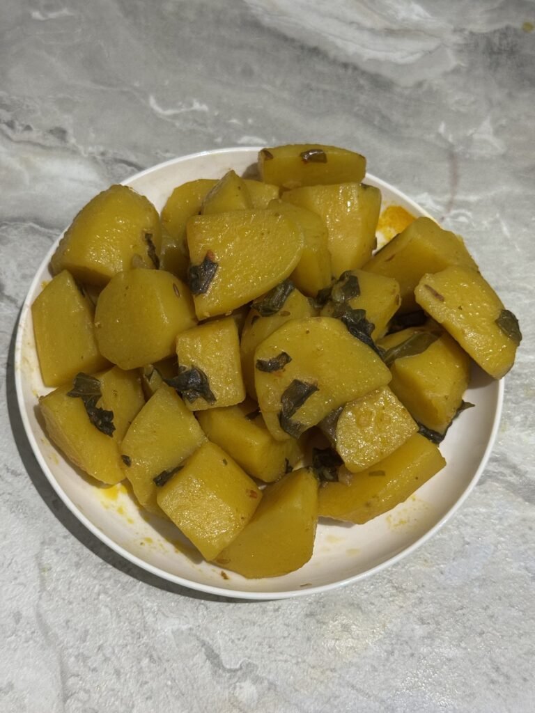 Cooked potato cubes removed from the pot and set aside on a plate