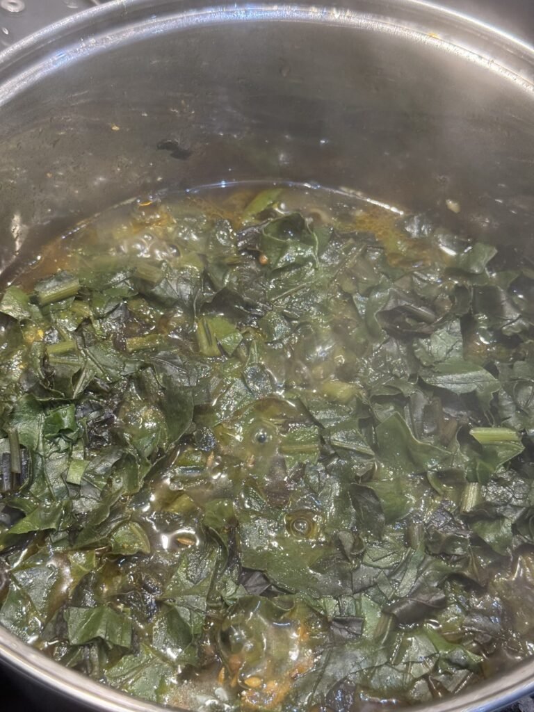 Blended spinach gravy simmering in the pot until the oil separates